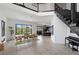 Bright, open dining area with modern table set, floor-to-ceiling windows, and stylish staircase at 12637 Penfield Ave, Las Vegas, NV 89138