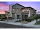 Contemporary home with gray stucco and stone exterior, landscaped front yard, and two-car garage at 12637 Penfield Ave, Las Vegas, NV 89138