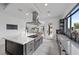 Open concept kitchen with a large island and stainless steel hood, seamlessly connecting to a dining area at 12637 Penfield Ave, Las Vegas, NV 89138
