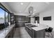 A modern kitchen with dark wood cabinets, stainless steel appliances, and a large island with a white countertop at 12637 Penfield Ave, Las Vegas, NV 89138