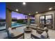 Inviting covered patio with outdoor seating, heaters, and a view of the sparkling pool and landscape at 12637 Penfield Ave, Las Vegas, NV 89138