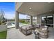 Relaxing covered patio featuring sleek outdoor seating, a pool view, and manicured landscaping at 12637 Penfield Ave, Las Vegas, NV 89138