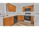 An efficient kitchen featuring warm wood cabinets, black appliances and a white countertop at 1300 S Arlington St # 120, Las Vegas, NV 89104