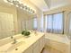 Bathroom featuring double sinks, a soaking tub, and a glass enclosed shower at 2119 Sunset Vista Ave, Henderson, NV 89052