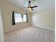 This is a cozy bedroom with neutral carpet, a ceiling fan, and a bright window at 2119 Sunset Vista Ave, Henderson, NV 89052