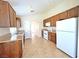 Bright kitchen featuring stainless steel sink, tile floors, white appliances, and wood cabinets at 2119 Sunset Vista Ave, Henderson, NV 89052