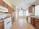 Bright kitchen with tile floors, white appliances, wood cabinets, and a cozy breakfast nook at 2119 Sunset Vista Ave, Henderson, NV 89052