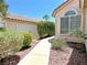 A quaint walkway leads to a charming home, surrounded by lush greenery and well-maintained landscaping at 2119 Sunset Vista Ave, Henderson, NV 89052