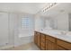 Bright bathroom with double sinks, tiled floors, glass-enclosed shower and large soaking tub at 2367 Tilden Way, Henderson, NV 89074