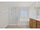 Bright bathroom featuring a glass enclosed shower, soaking tub, tiled floors and a single vanity at 2367 Tilden Way, Henderson, NV 89074