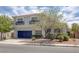 Inviting two-story home with desert landscaping, a blue garage door, and decorative window awnings at 2367 Tilden Way, Henderson, NV 89074