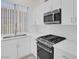 Kitchen features white cabinets, stainless steel appliances, and stone countertops at 2367 Tilden Way, Henderson, NV 89074