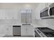 Kitchen features white cabinets, stainless steel appliances, and stone countertops and backsplash at 2367 Tilden Way, Henderson, NV 89074