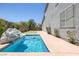 A backyard features a pool with rock decor, concrete patio, and mature landscaping at 2367 Tilden Way, Henderson, NV 89074