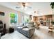 This living room features leather seating, ceiling fans, and a view of the kitchen and backyard at 285 Rain Quail Way, Henderson, NV 89012