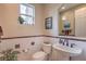 Elegant powder room featuring marble walls, a sleek pedestal sink, and decorative accents at 2982 Hammerwood Dr, Las Vegas, NV 89135