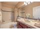 Well-lit bathroom with white tiles, single sink vanity, and bathtub at 2982 Hammerwood Dr, Las Vegas, NV 89135