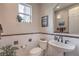 Elegant powder room with pedestal sink, decorative tile accents, and a window for natural light at 2982 Hammerwood Dr, Las Vegas, NV 89135