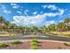 Welcoming community entrance with lush landscaping, mature trees, and stone signage at 2982 Hammerwood Dr, Las Vegas, NV 89135