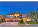 Elegant two-story home featuring a three-car garage, brick accents, and well-manicured landscaping at 2982 Hammerwood Dr, Las Vegas, NV 89135