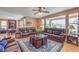 Spacious living room features leather sofas, area rug, ceiling fan, and lots of natural light at 2982 Hammerwood Dr, Las Vegas, NV 89135
