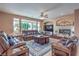 Comfortable living room with a fireplace, ceiling fan, and ample natural light at 2982 Hammerwood Dr, Las Vegas, NV 89135