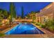 The backyard boasts a beautiful pool with a basketball hoop and ambient lighting for evening swims at 2982 Hammerwood Dr, Las Vegas, NV 89135
