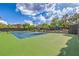 Community tennis court surrounded by lush landscaping, offering a recreational space at 2982 Hammerwood Dr, Las Vegas, NV 89135