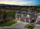 Aerial view of a two-story home with solar panels, a three-car garage and a landscaped yard at dusk at 3204 Rutledge Dr, Las Vegas, NV 89120