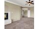 Spacious living room featuring a fireplace, neutral carpet and ceiling fan with access to the upper level at 3204 Rutledge Dr, Las Vegas, NV 89120