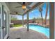 Relaxing backyard pool area with a covered patio, ceiling fans, and lush landscaping at 3204 Rutledge Dr, Las Vegas, NV 89120