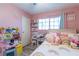Charming pink bedroom featuring bright natural light, laminate flooring, and ample space for play and rest at 3682 Deer Creek Way, Las Vegas, NV 89115
