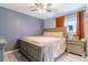 Comfortable bedroom with a large bed, soft lighting, and warm accents with orange curtains at 3682 Deer Creek Way, Las Vegas, NV 89115
