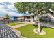 Attractive single-story home with artificial grass, a horizontal fence, and mature tree at 3682 Deer Creek Way, Las Vegas, NV 89115