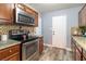A well-lit kitchen with stainless steel appliances, tile backsplash and wood finish cabinets at 3682 Deer Creek Way, Las Vegas, NV 89115