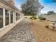 Picturesque backyard with a stone-paved patio, mature tree, and a classic water fountain at 3957 Placita Del Lazo, Las Vegas, NV 89120