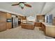 Well-lit kitchen with an island, wood cabinets, stainless steel appliances, and tile flooring at 4139 Abernethy Forest Pl, Las Vegas, NV 89141
