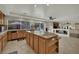 Open kitchen boasts a center island, tile countertops, and wood cabinets with backyard views at 4139 Abernethy Forest Pl, Las Vegas, NV 89141