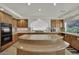 Bright kitchen featuring a spacious island with countertops, cabinets, and cooking range at 4139 Abernethy Forest Pl, Las Vegas, NV 89141