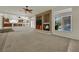 Spacious living room featuring fireplace, carpeted flooring and large windows overlooking backyard pool at 4139 Abernethy Forest Pl, Las Vegas, NV 89141