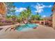 Backyard pool with tropical landscaping, rock waterfall, spa, and covered patio area at 4139 Abernethy Forest Pl, Las Vegas, NV 89141