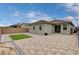 Spacious backyard featuring a paver patio, small patch of artificial turf, and block wall fencing at 4293 Nopal Serrano Ave, Las Vegas, NV 89141
