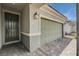 Close-up view of a home's entrance, highlighting the front door, garage, and stone-paved driveway at 4293 Nopal Serrano Ave, Las Vegas, NV 89141