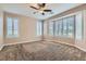 Large bedroom with carpet flooring, ceiling fan, and windows with plantation shutters at 4311 Fiore Bella Blvd, Las Vegas, NV 89135