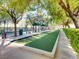 Bocce ball court provides a tranquil, shaded space for relaxed outdoor enjoyment with green hedges at 4311 Fiore Bella Blvd, Las Vegas, NV 89135
