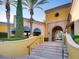 Elegant entrance to the building has blue awnings, tiled steps and a yellow facade with manicured shrubbery at 4311 Fiore Bella Blvd, Las Vegas, NV 89135