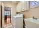 Functional laundry room with a washer, dryer, utility sink, and storage cabinets for efficient organization at 4311 Fiore Bella Blvd, Las Vegas, NV 89135