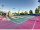 Outdoor pickleball court with artificial turf and a green net, surrounded by lush trees and green foliage at 4311 Fiore Bella Blvd, Las Vegas, NV 89135