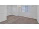 Large, neutral carpeted bedroom with base molding, white walls, and natural light from two windows at 4807 Leadership Ct, North Las Vegas, NV 89031