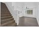 Sun-filled living room with carpeted staircase, hardwood floors, and a large window at 4807 Leadership Ct, North Las Vegas, NV 89031